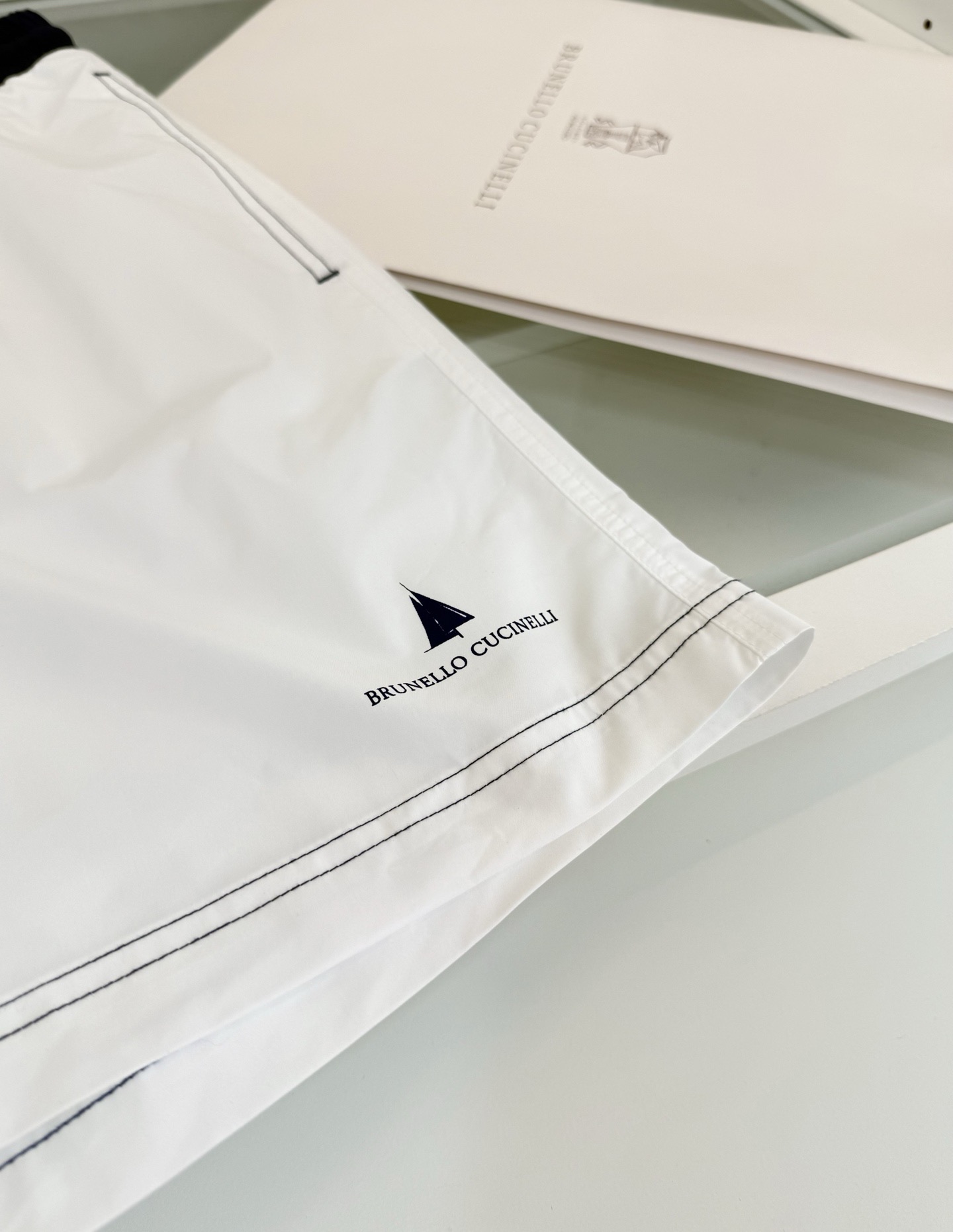 Шорты мужские в стиле Brunello Cucinelli белого цвета с контрастным поясом (пляжные)