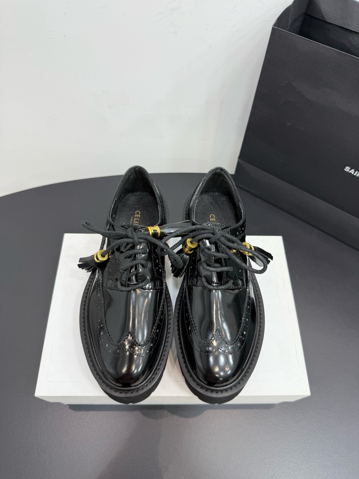 Лоферы женские Celine на шнуровке из натуральной лаковой кожи черного цвета