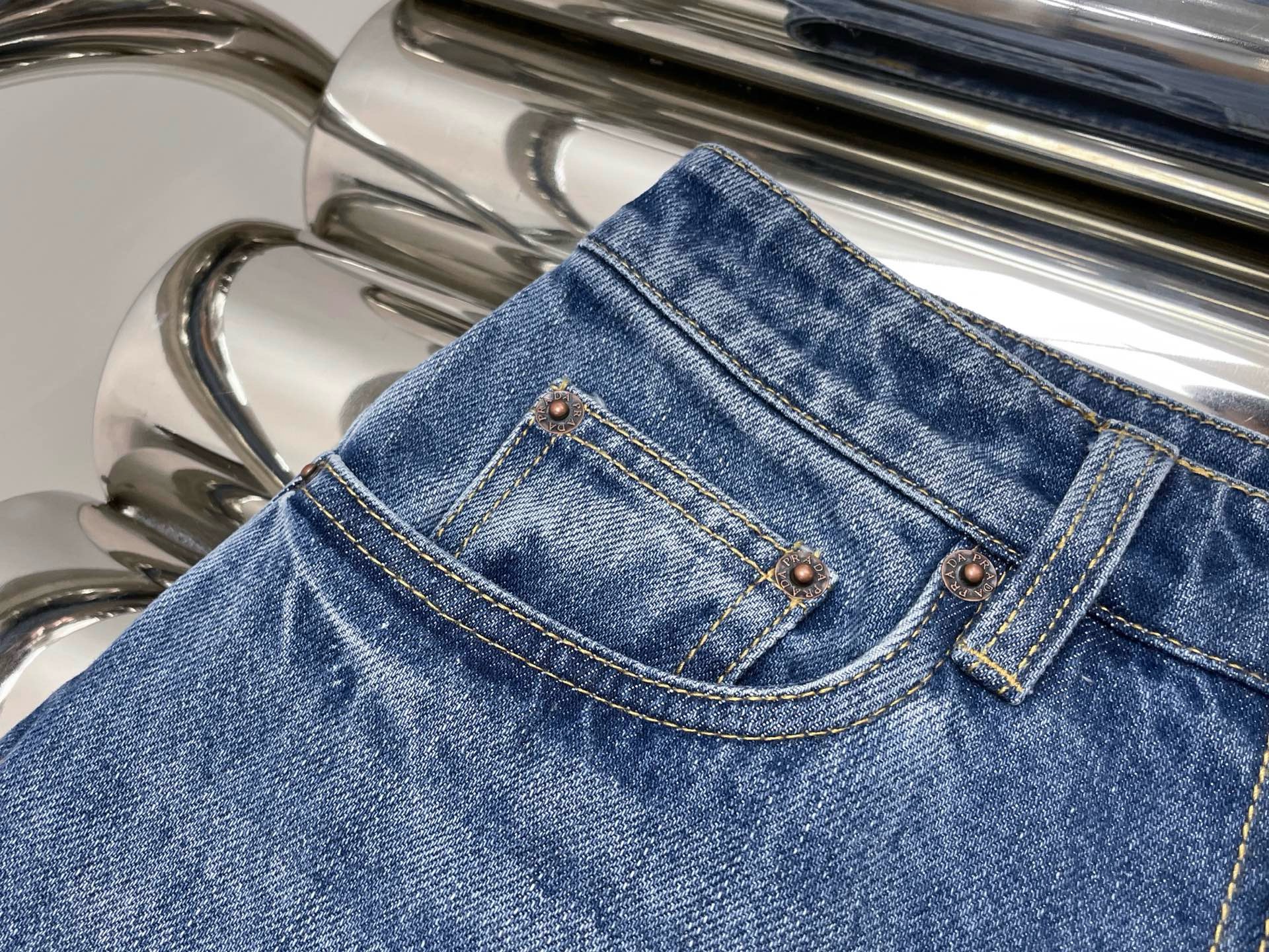 Джинсы женские в стиле Prada синего цвета с треугольным логотипом