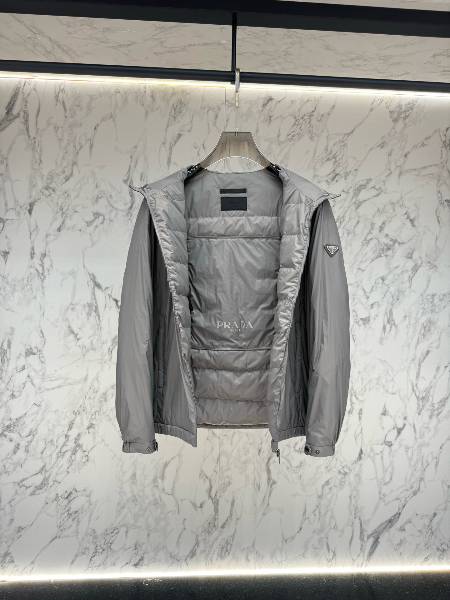 Пуховик Prada Re-Nylon серого цвета с капюшоном и натуральным пухом