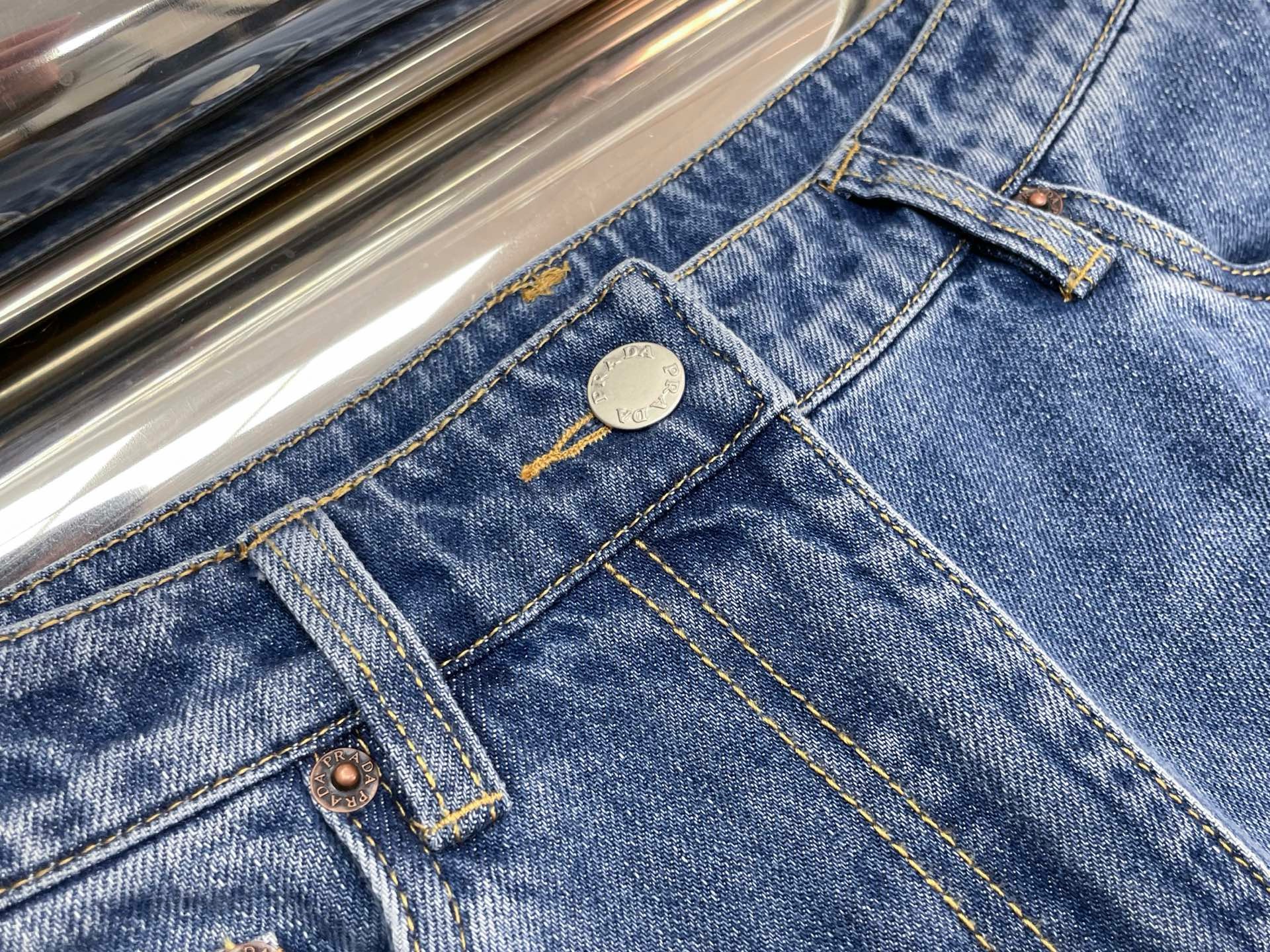 Джинсы женские в стиле Prada синего цвета с треугольным логотипом